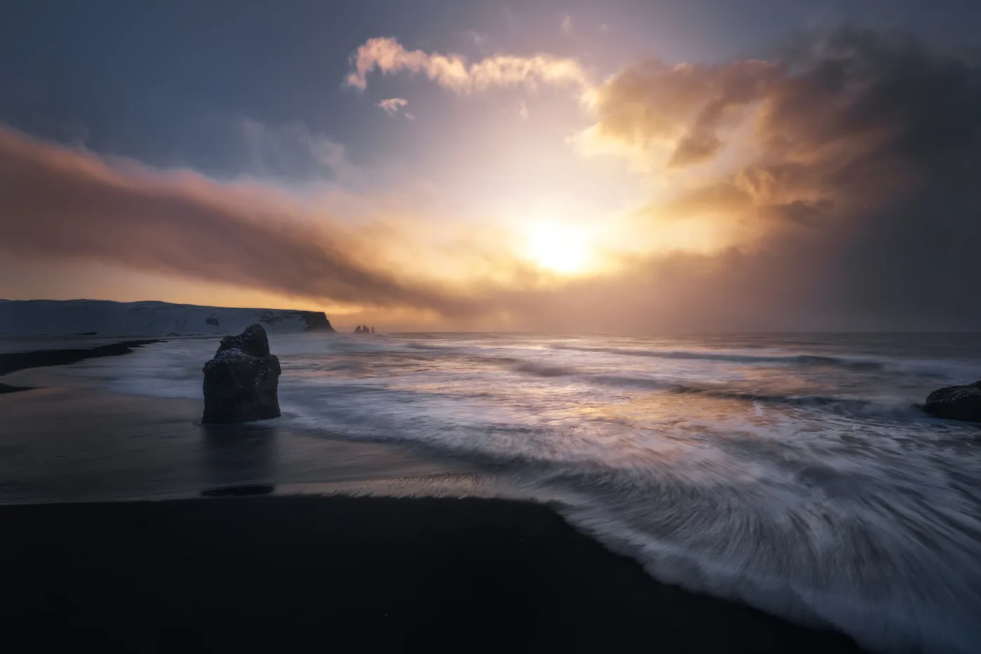 Amanecer sobre la playa negra de Reynisfjara con los Reynisdrangar al fondo, sur de Islandia