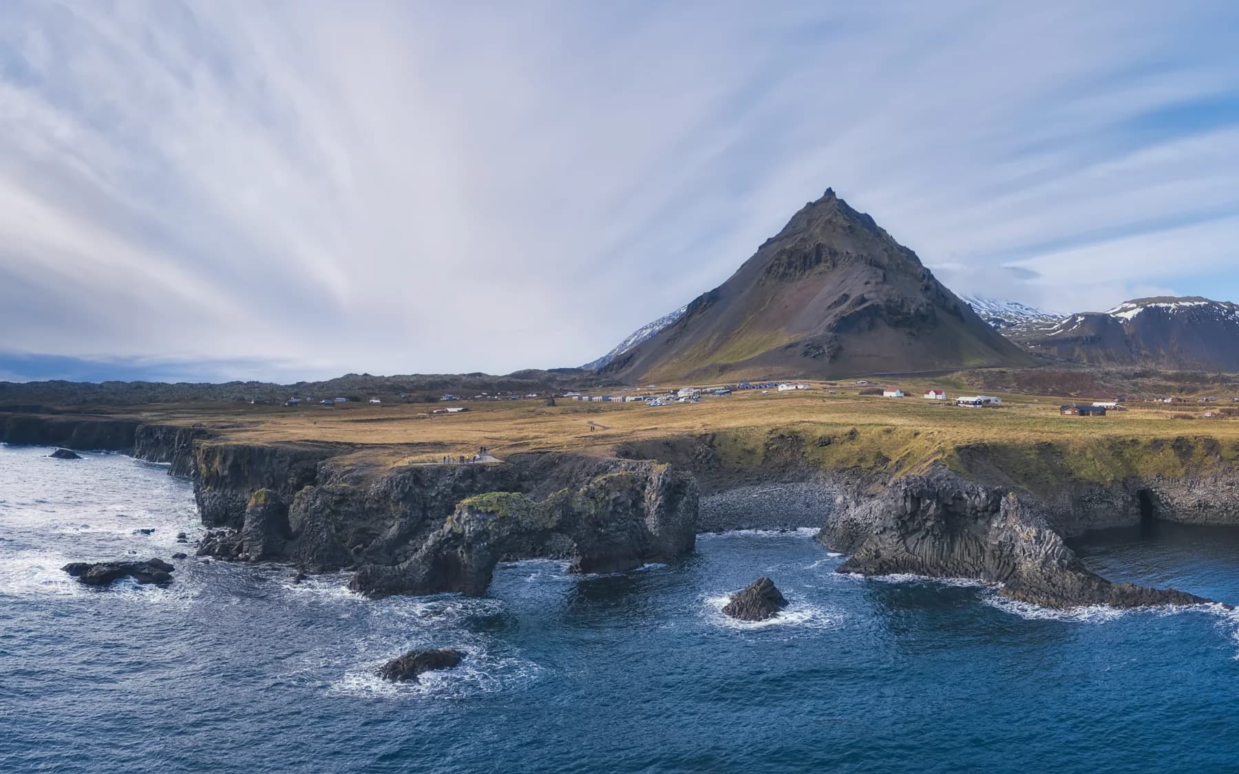 Vista panorámica aérea de Arnarstapi, los arcos de piedra de la costa y el pico Stapafell, Snæfellsnes