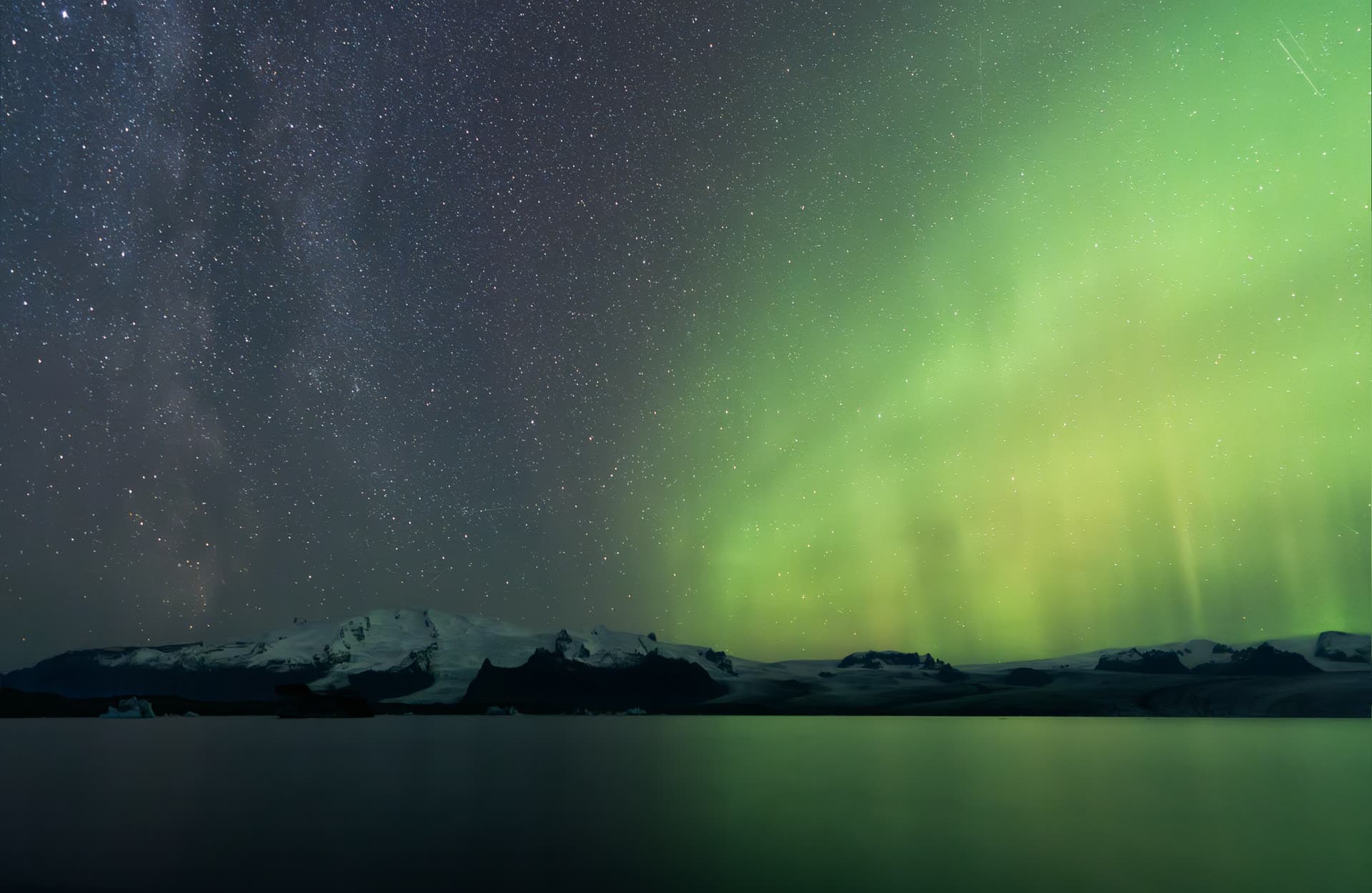 Auroras boreales verdes sobre el glaciar Breiðamerkurjökull en Islandia