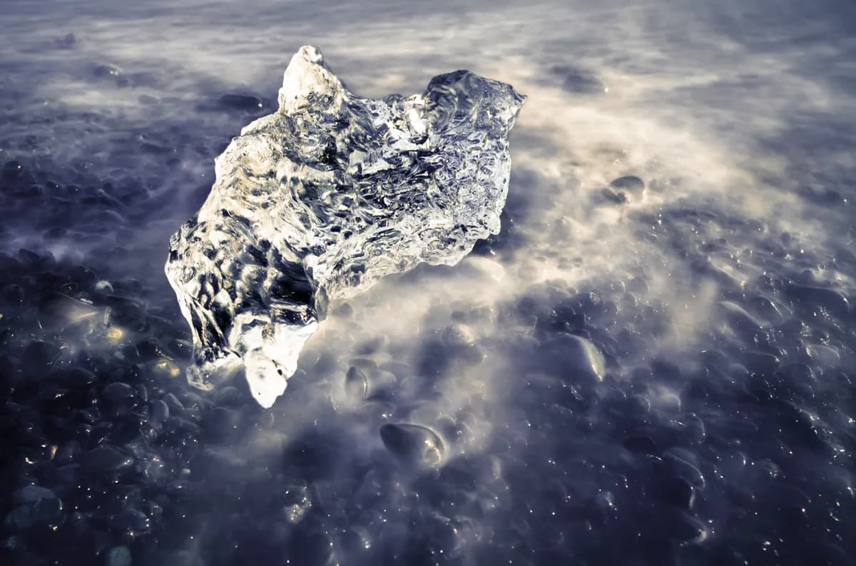 Detalle en larga exposición de un bloque de hielo sobre la arena negra de la Playa de los Diamantes
