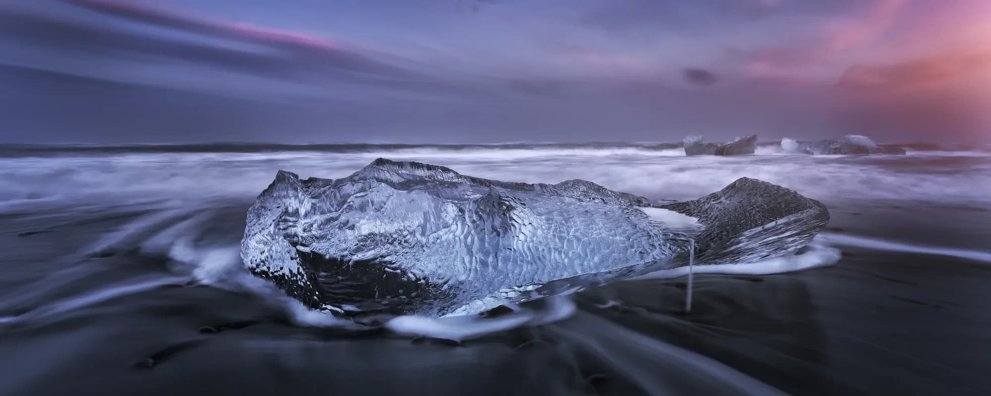 Icebergs de hielo translúcido sobre la arena negra volcánica de la Playa de los Diamantes, sureste de Islandia