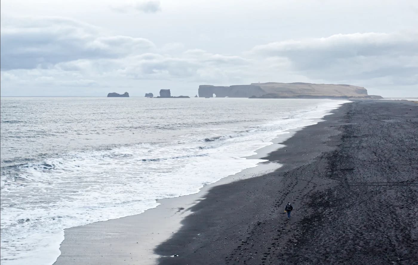 Vista desde Dyrhólaey de la playa negra del sur de Islandia extendiéndose hacia Reynisfjara en el horizonte