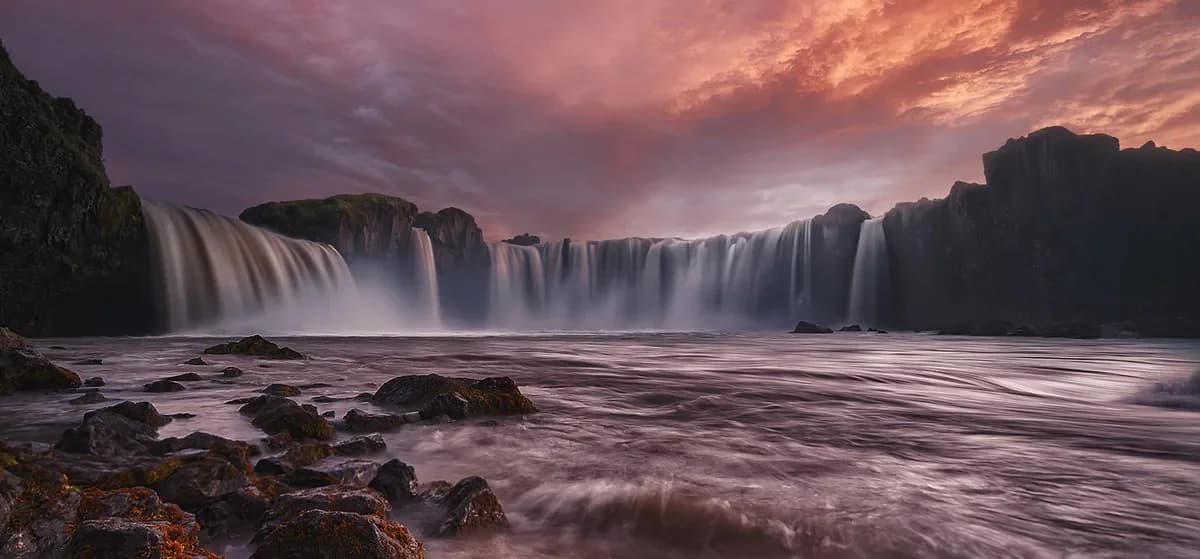 Cascada Godafoss al atardecer con cielo rosado, norte de Islandia