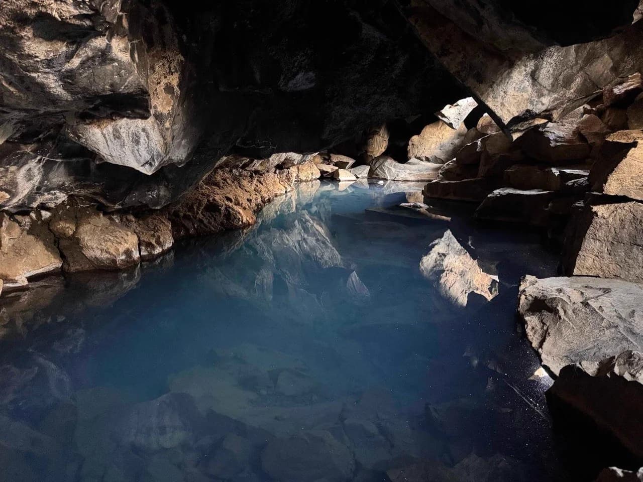Interior de la cueva de Grjótagjá con su piscina termal de agua azul turquesa, norte de Islandia