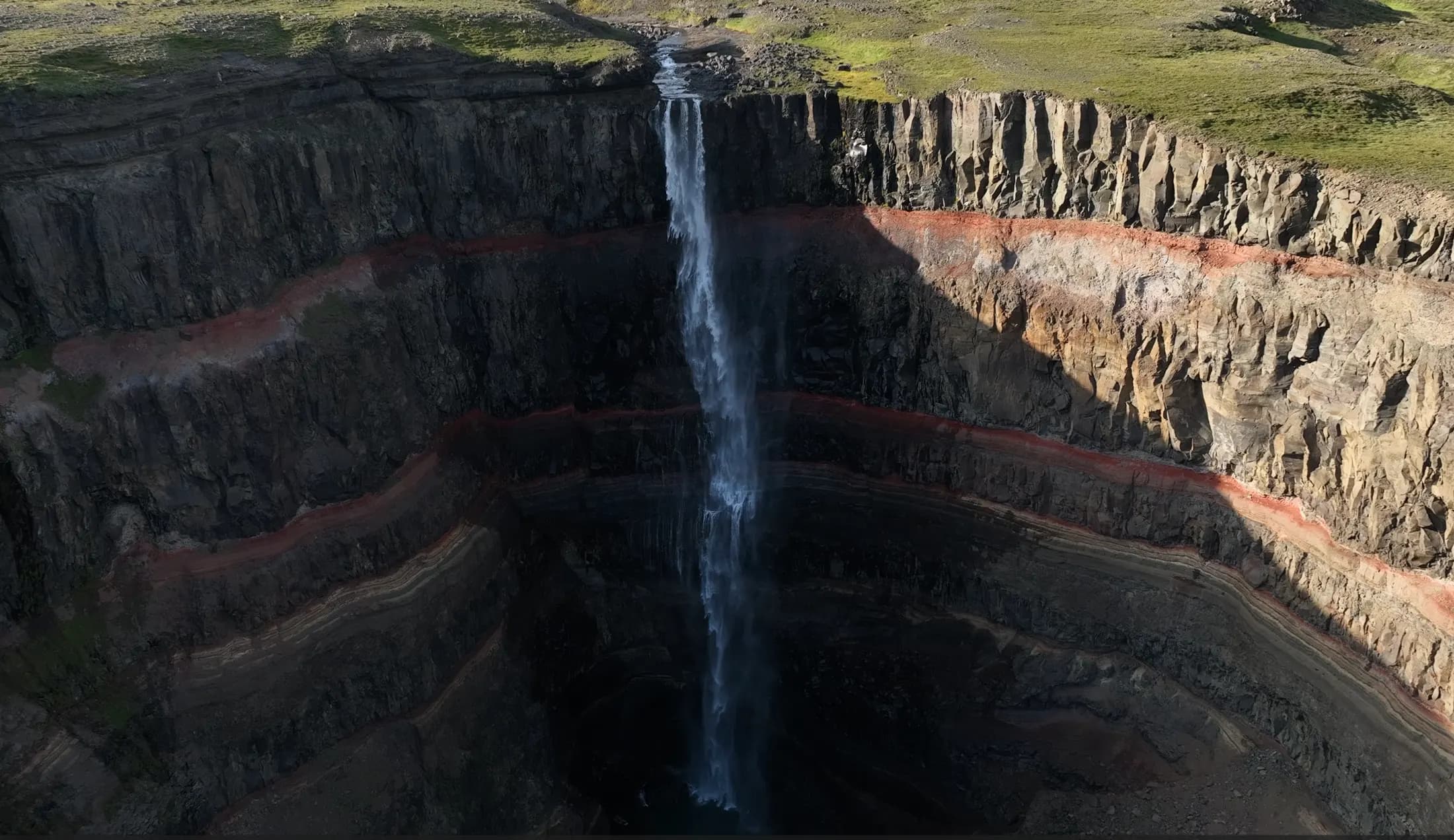 Cascada Hengifoss con sus características capas de arcilla roja en el cañón, este de Islandia