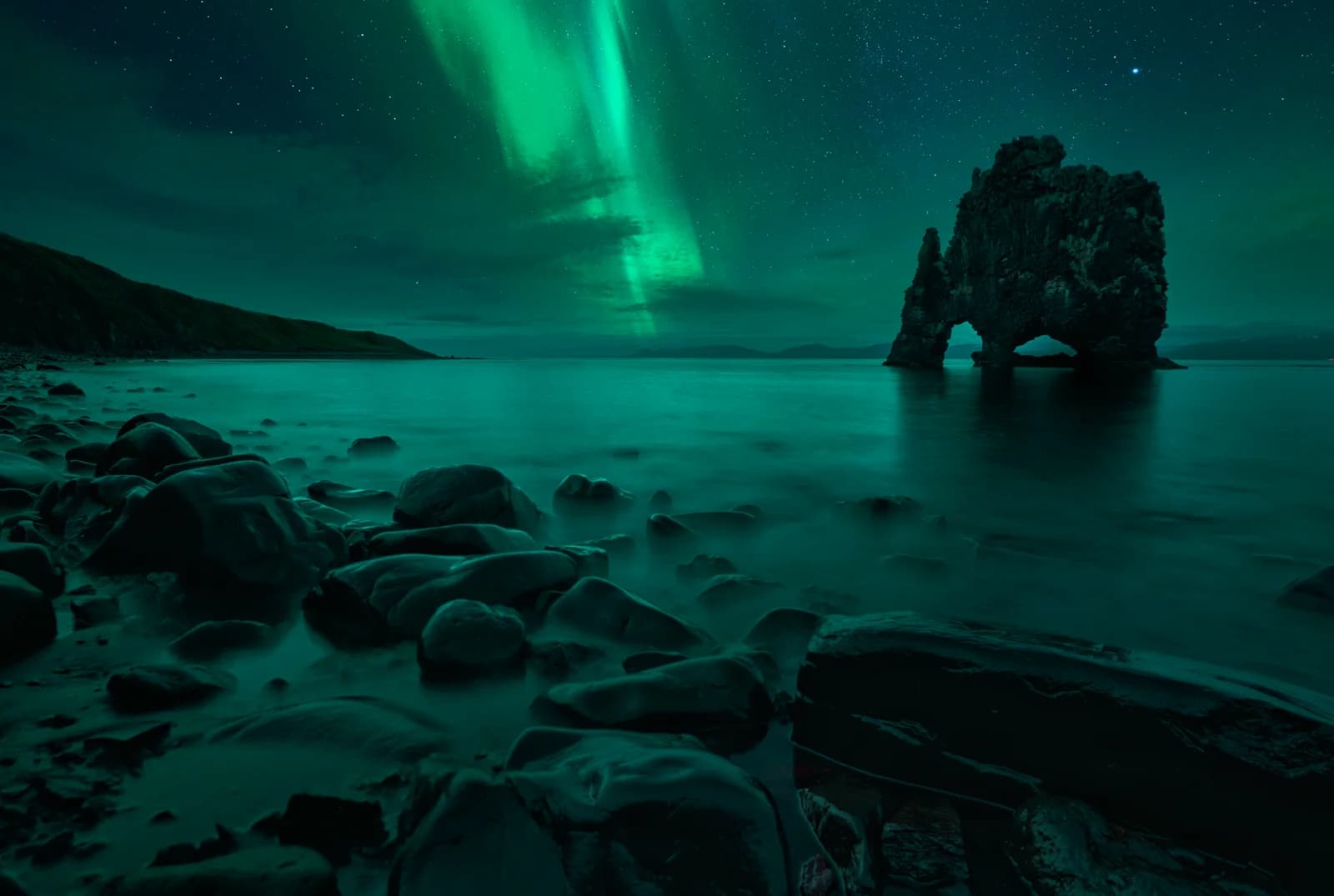 La roca Hvítserkur bajo una aurora boreal verde, península de Vatnsnes, norte de Islandia