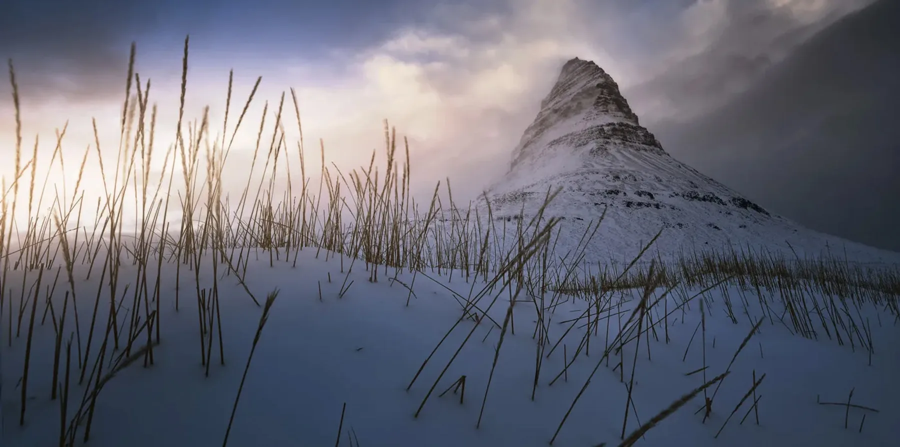 Vista panorámica de la montaña Kirkjufell nevada al atardecer, península de Snæfellsnes