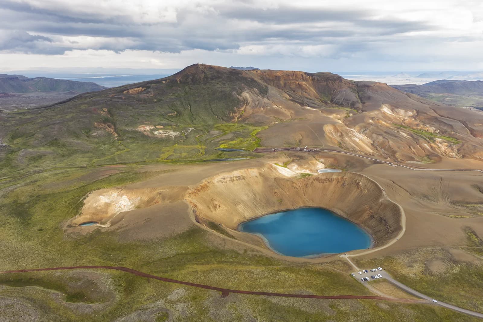 Vista aérea del cráter Víti con su lago turquesa y la central geotérmica de Krafla al fondo, norte de Islandia