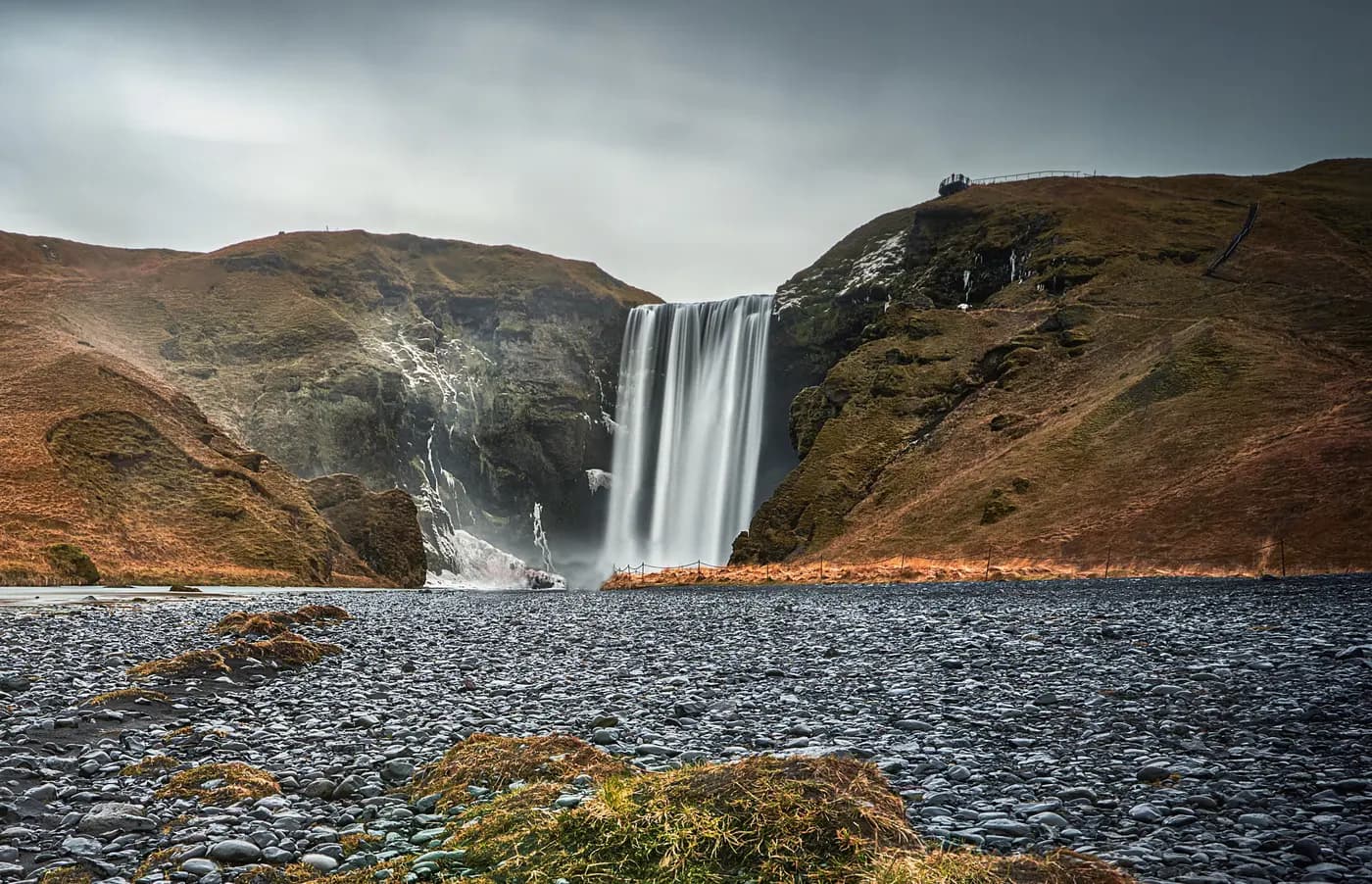 Cascada Skógafoss en noviembre con hielo y spray congelado en el suelo, sur de Islandia — zona de acceso peligrosa en invierno
