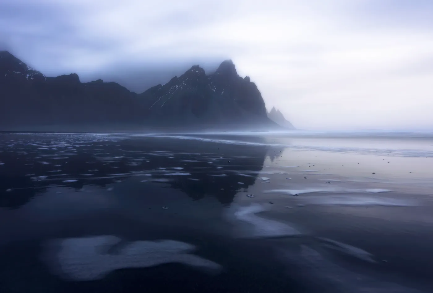 Monte Vestrahorn envuelto en niebla con reflejo en la arena, Stokksnes