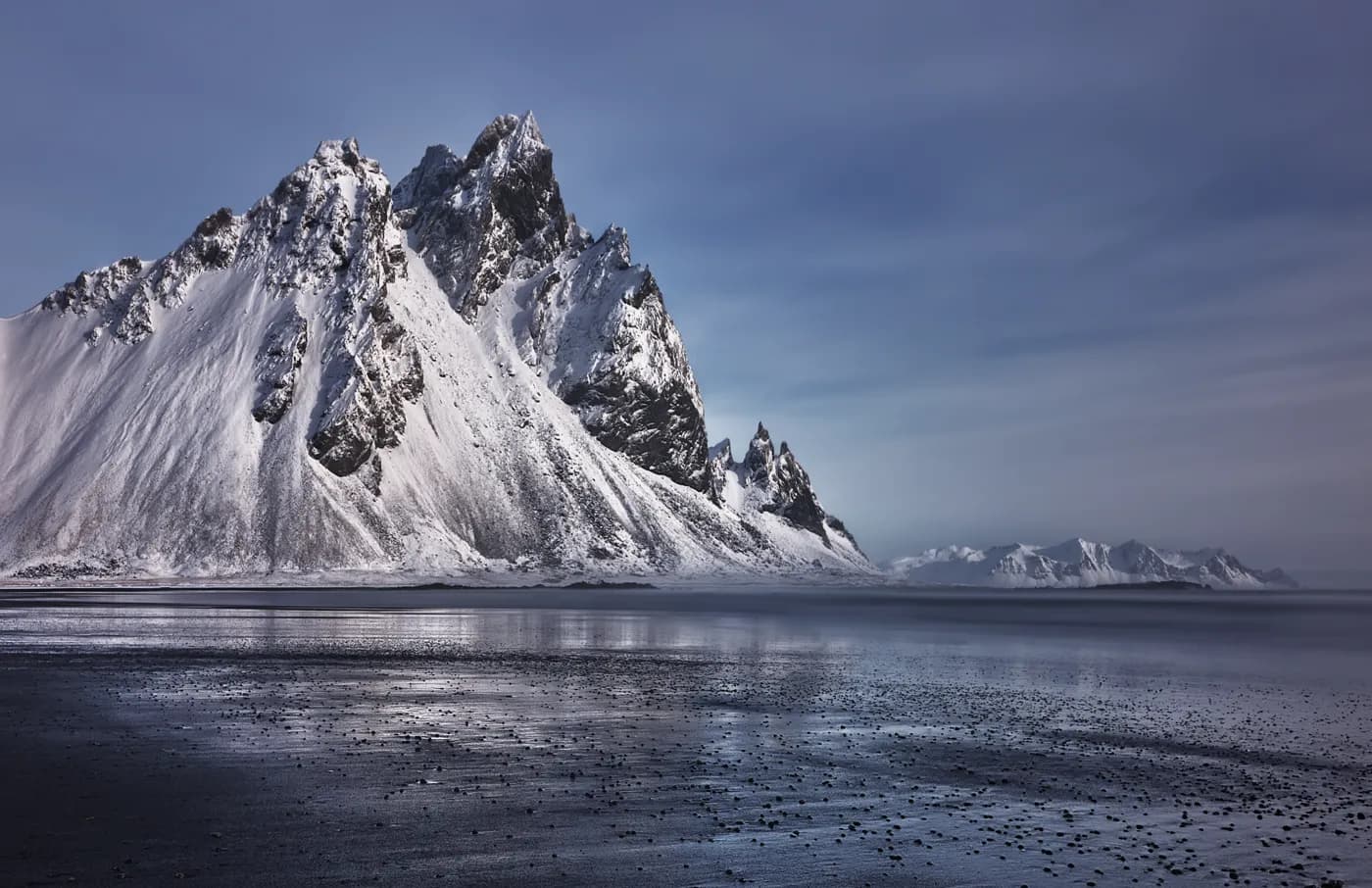 Monte Vestrahorn nevado en tonos azulados con reflejo en la arena mojada, Stokksnes