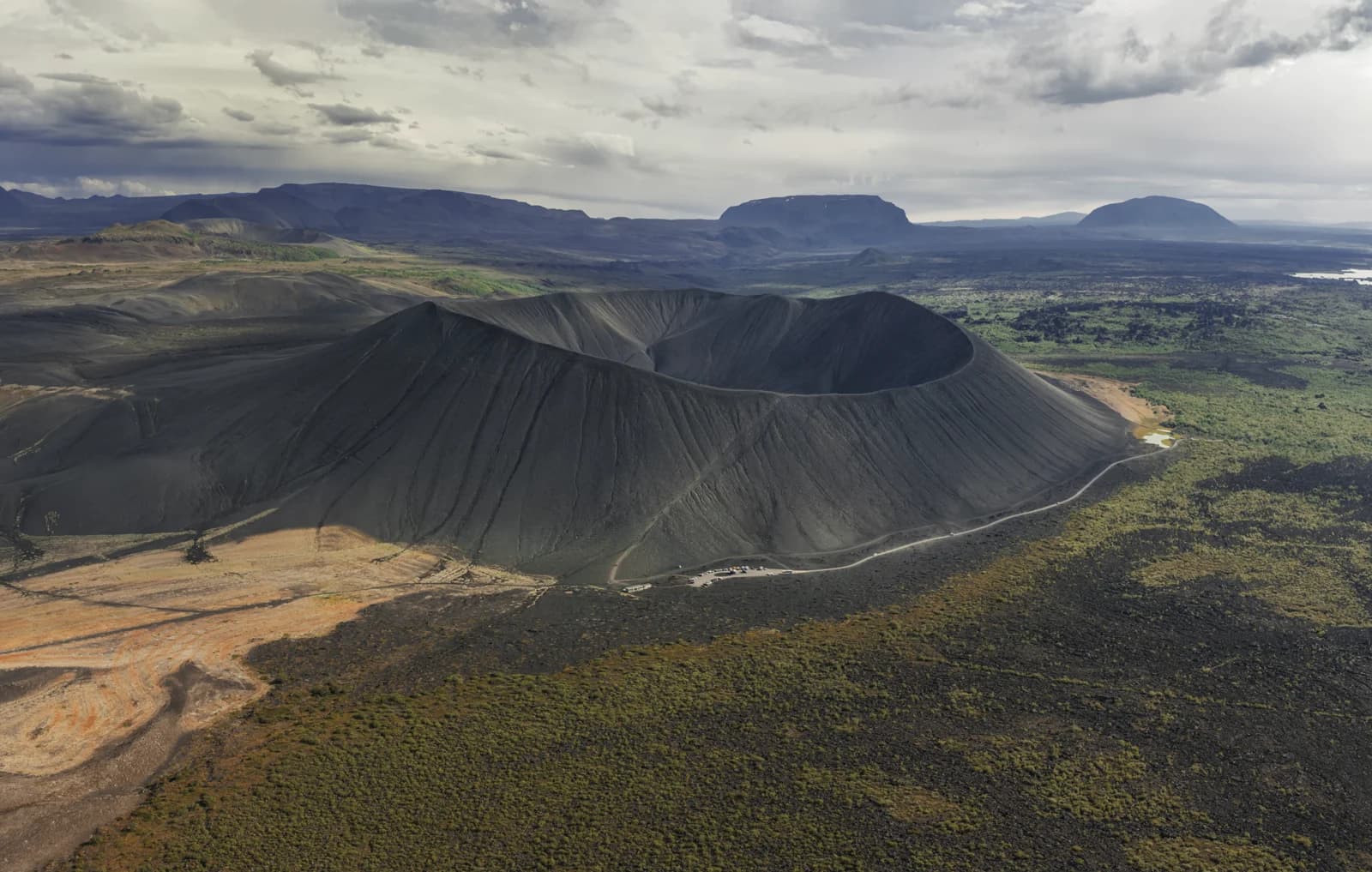 Vista aérea del cráter Hverfjall con el sendero y el aparcamiento en su base, norte de Islandia