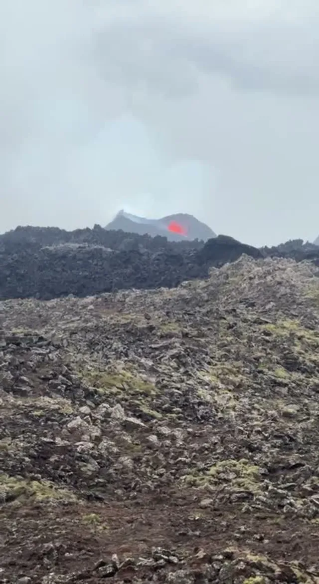 Vista a distancia del resplandor de la erupción de Reykjanes desde el sendero, julio de 2025