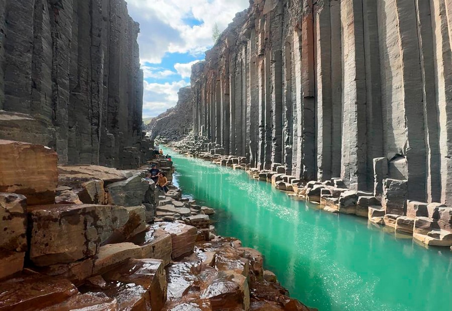 Vista desde el nivel del río mostrando las columnas de basalto y las aguas turquesas