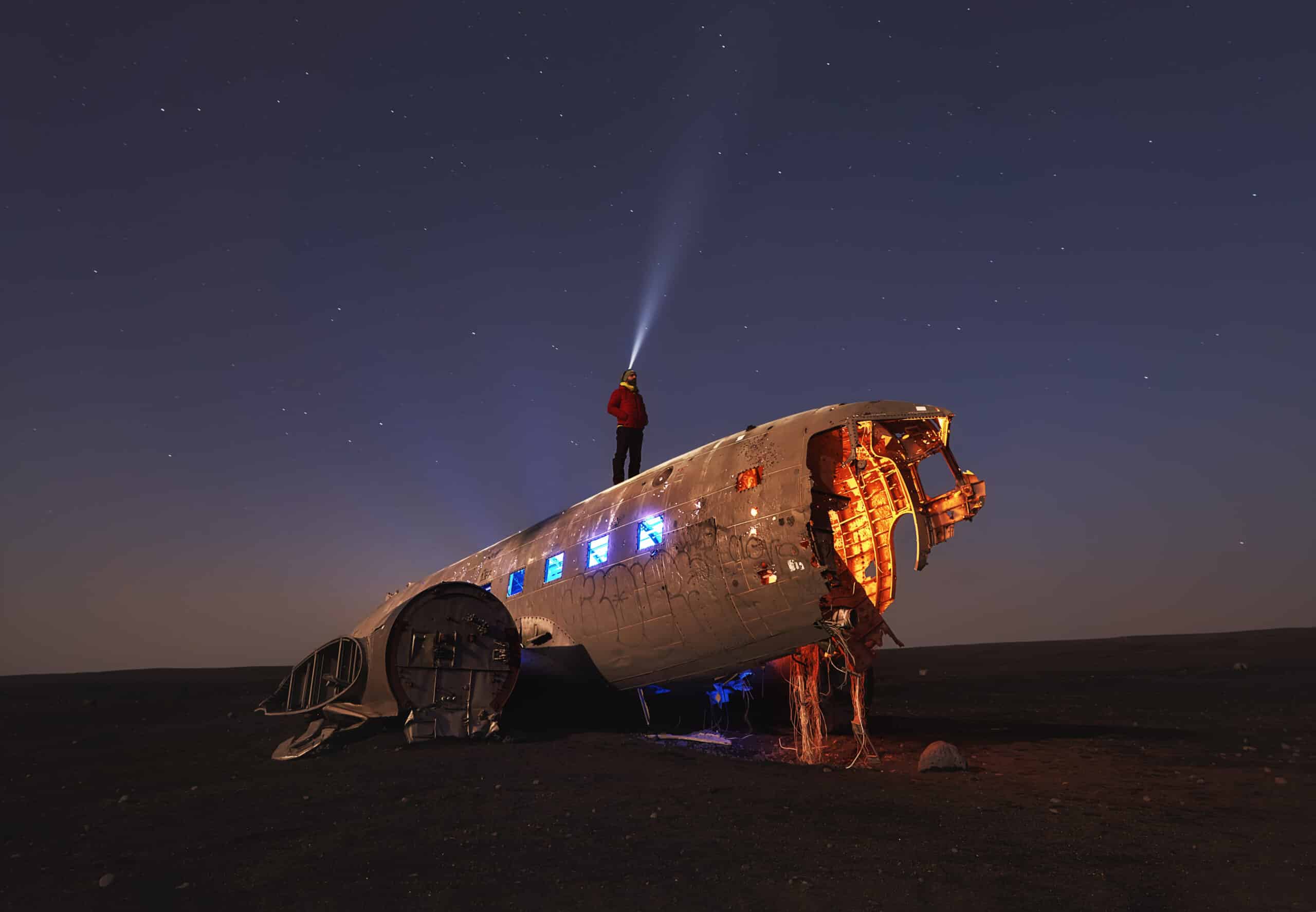 Aurora boreal en Islandia con dos personas a contraluz bajo el cielo iluminado