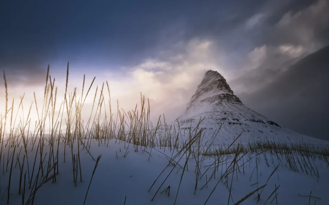 Monte Kirkjufell nevado al amanecer en invierno con luz rosada en el cielo, Islandia peninsula-snaefellsnes