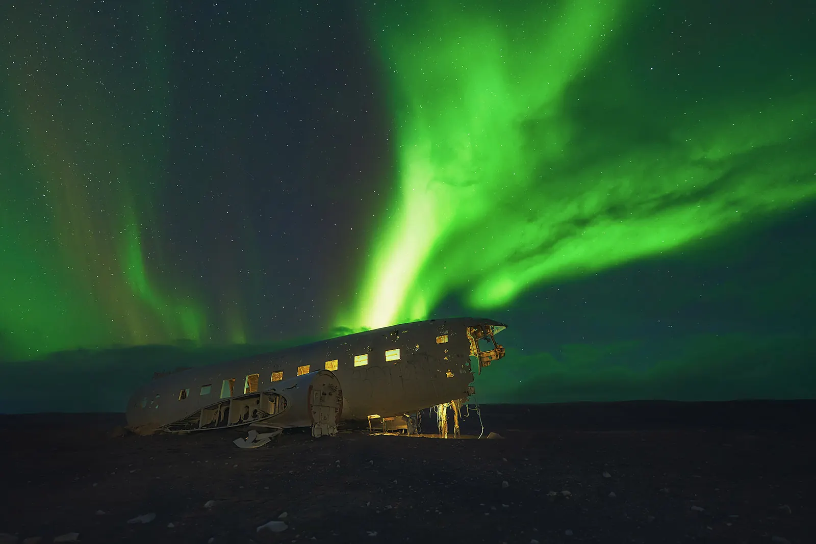 Aurora boreal en Islandia sobre avión estrellado, Sólheimasandur Aurora boreal en Islandia sobre el avión estrellado DC3 en la playa negra de Sólheimasandur, sur de Islandia