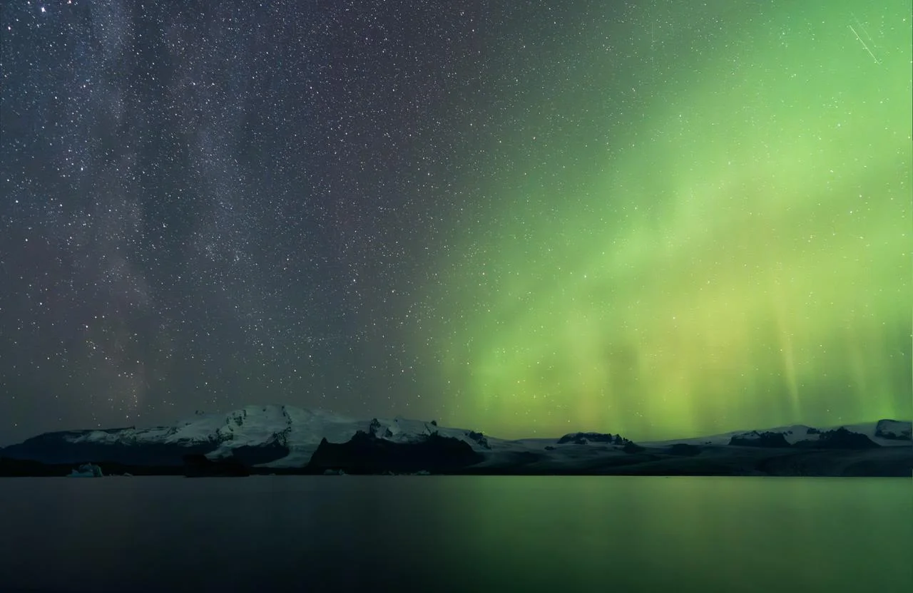 Aurora boreal verde sobre glaciares y la Vía Láctea en Islandia