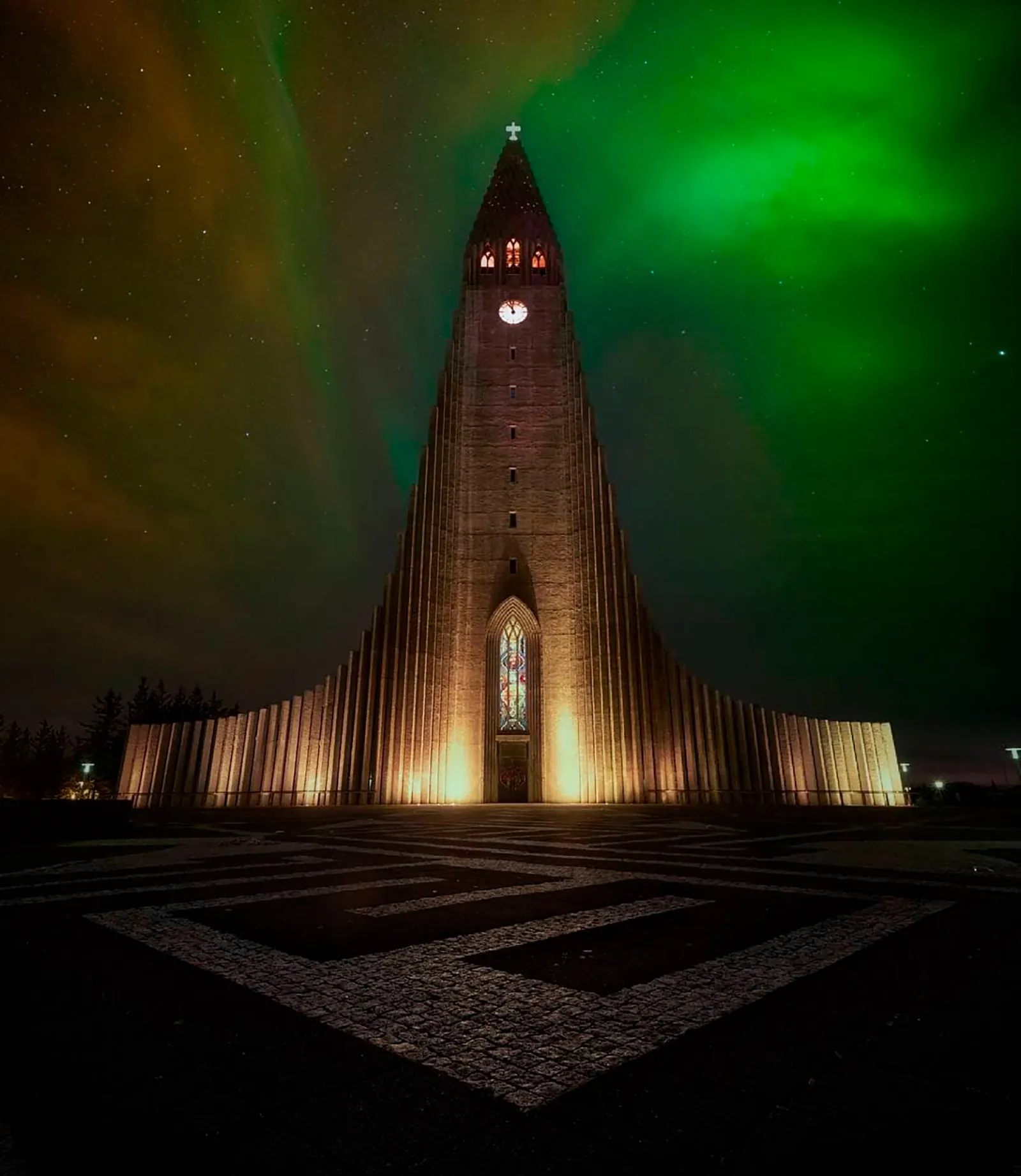 Hallgrímskirkja iluminada con aurora boreal verde sobre Reikiavik, Islandia