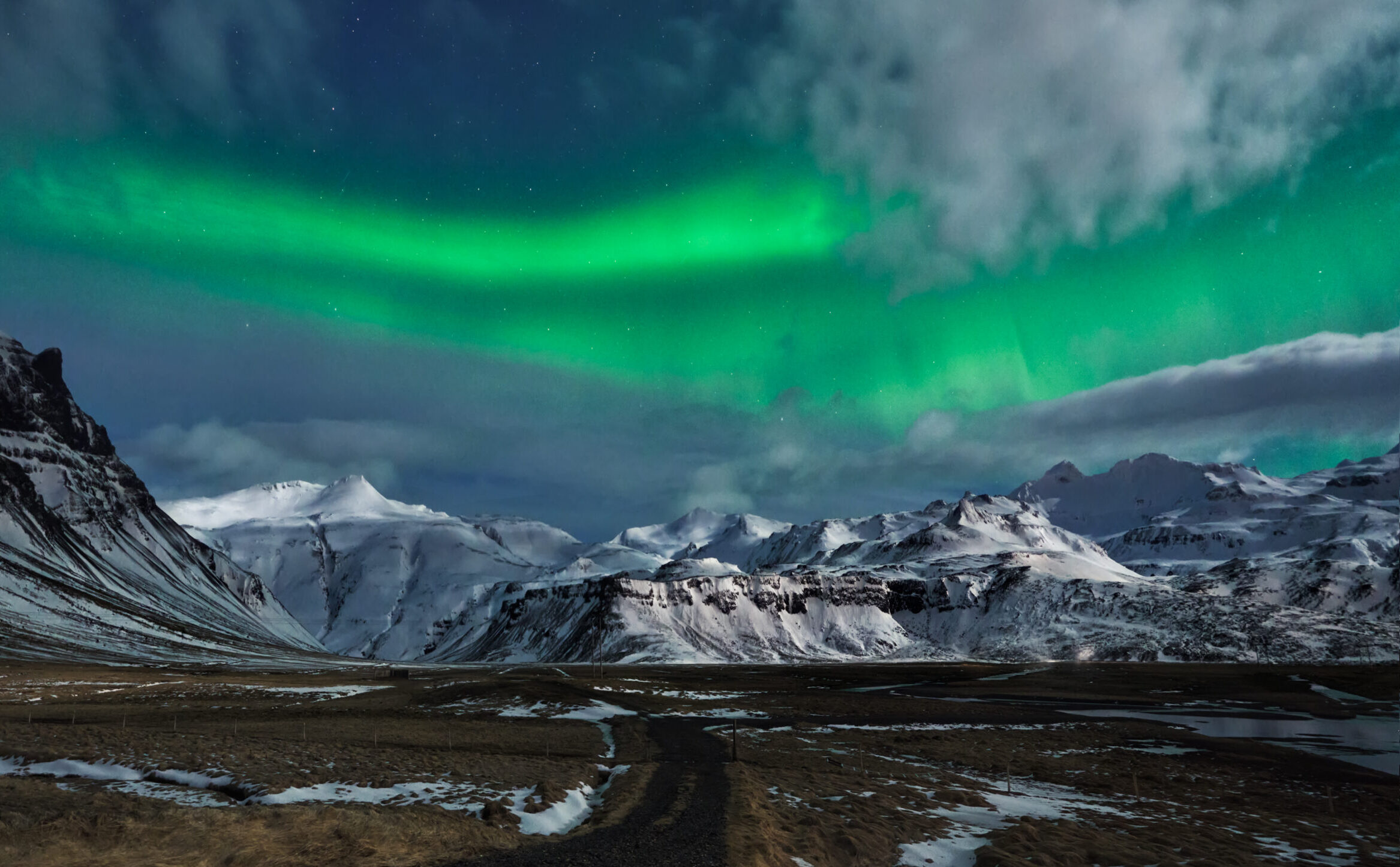 Auroras boreales sobrepeninsula-snaefellsnes, Islandia Auroras boreales verdes sobre las montañas nevadas y el glaciar Snæfellsjökull en la peninsula-snaefellsnes, Islandia