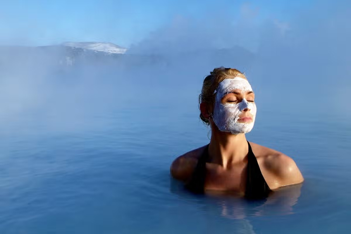 Mujer disfrutando del baño en la Blue Lagoon con mascarilla de barro, Islandia