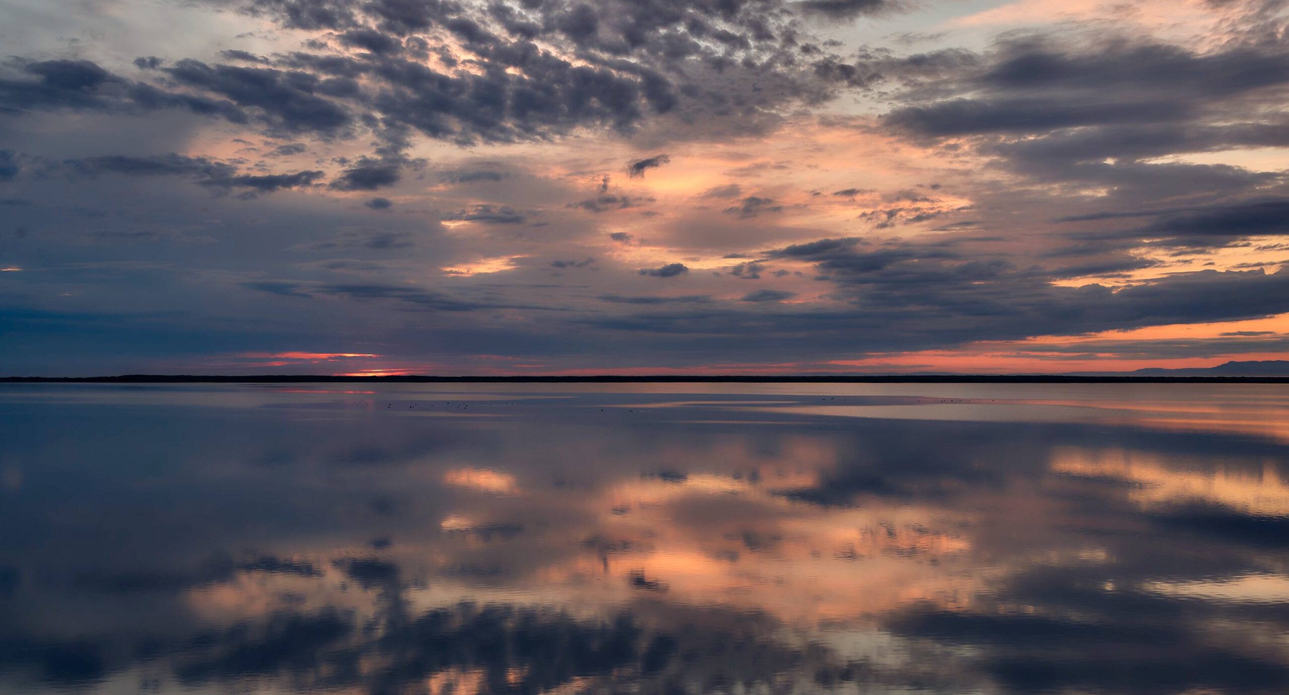 Atardecer con reflejo en Snæfellsnes, Islandia Espectacular atardecer reflejado en el agua con cielo naranja y dorado en la península de Snæfellsnes, Islandia