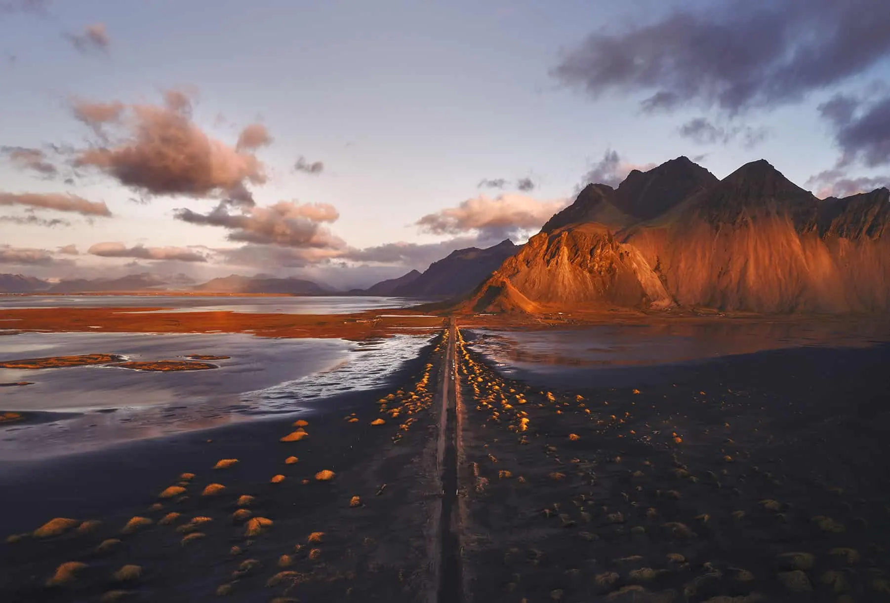 Camino de acceso a Stokksnes con el Vestrahorn al fondo al atardecer Camino de acceso a Stokksnes con el monte Vestrahorn al fondo al atardecer en Islandia