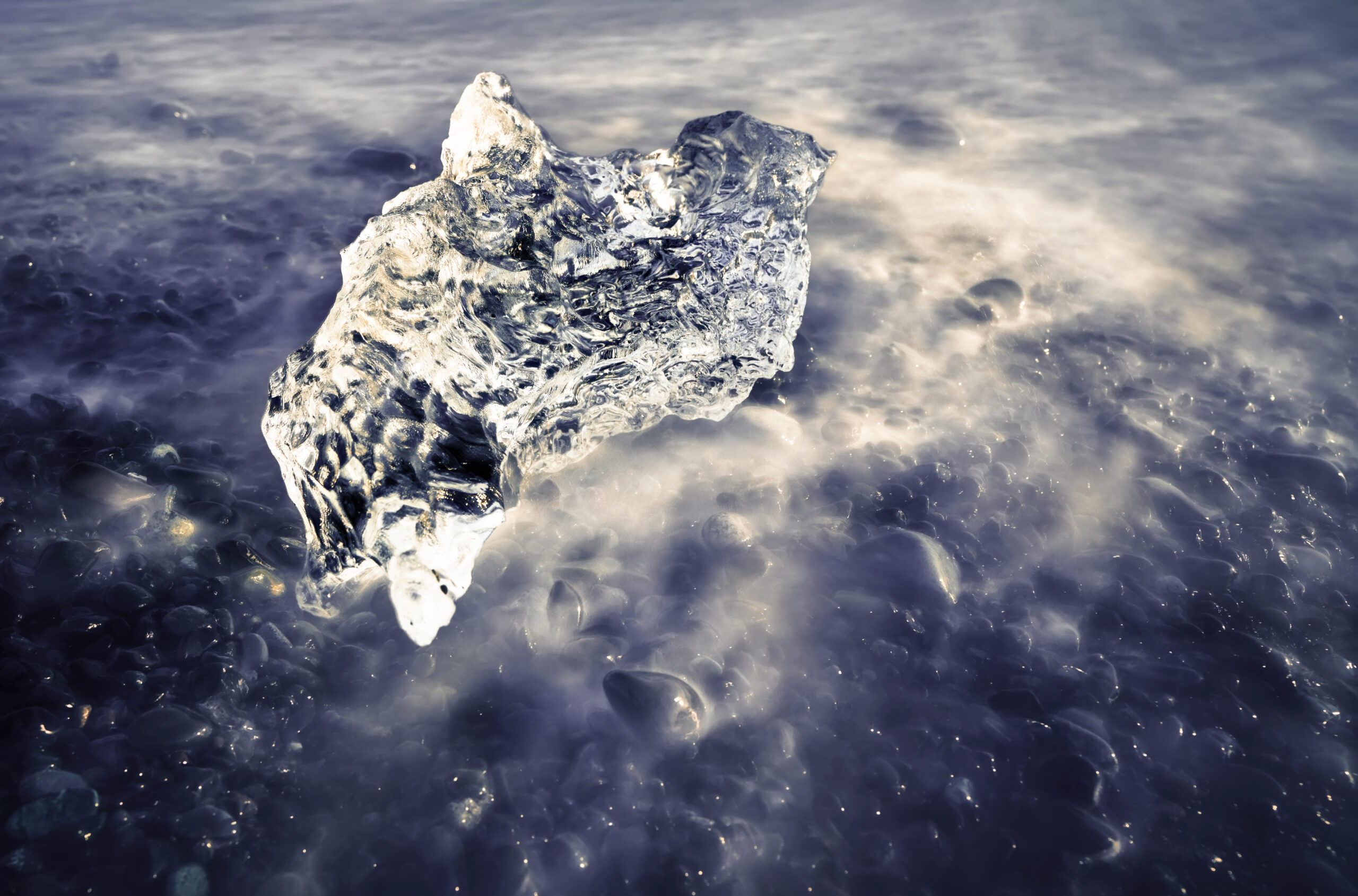 Primer plano de hielo glaciar con agua en movimiento en Diamond Beach Islandia